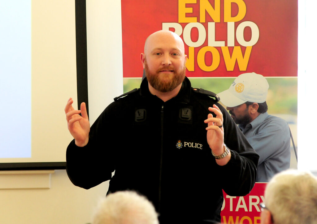 MDP officer giving a speech in front of attendees at the Internet Safety Poster competition.