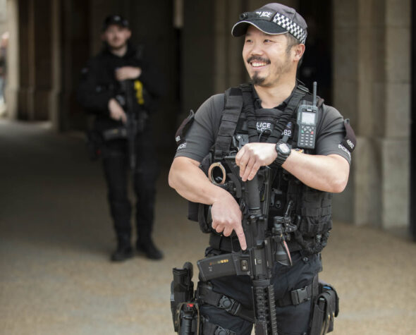 Ministry of Defence Police Officer smiling at Horse Guards in London holding a gun